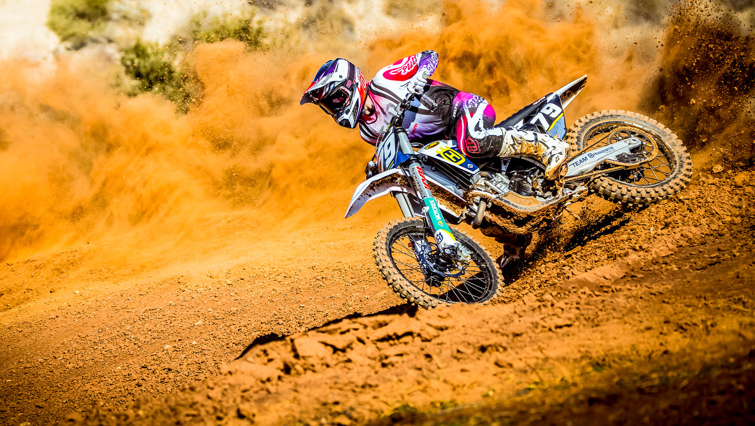 Motocross rider on a track, riding through a berm